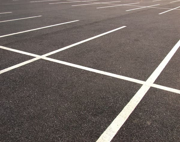 Black new pavement with white lanes in a parking lot,