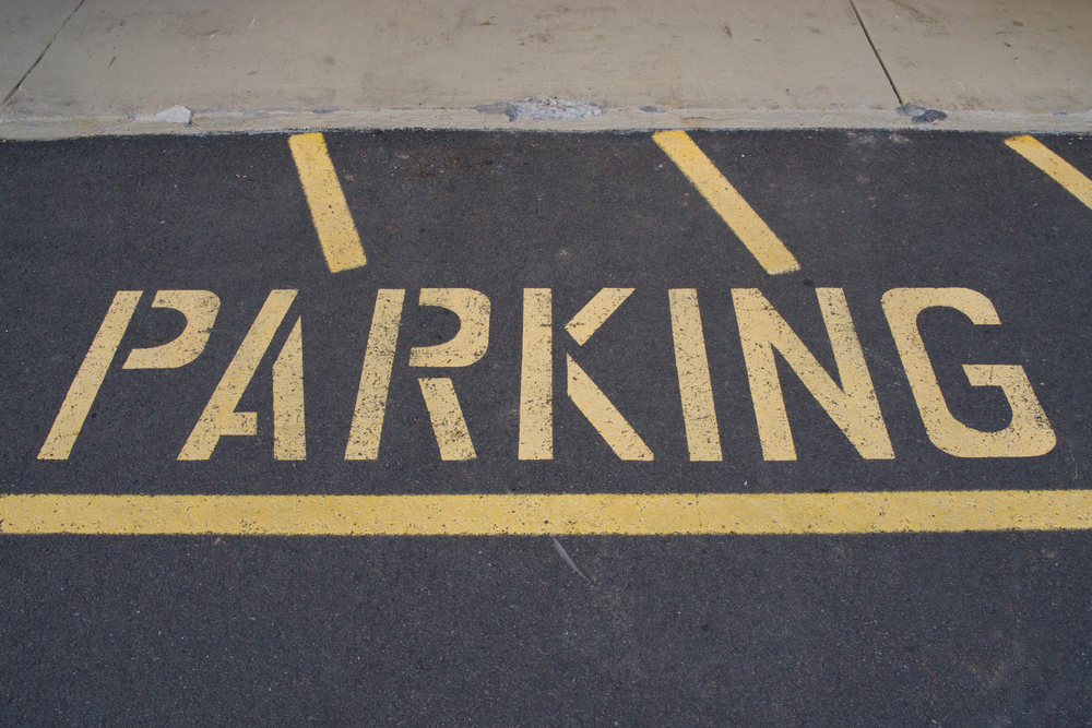 Parking lot signage on asphalt sits on a sunny day as Neyra Paving explains their striping and signage services for commercial properties